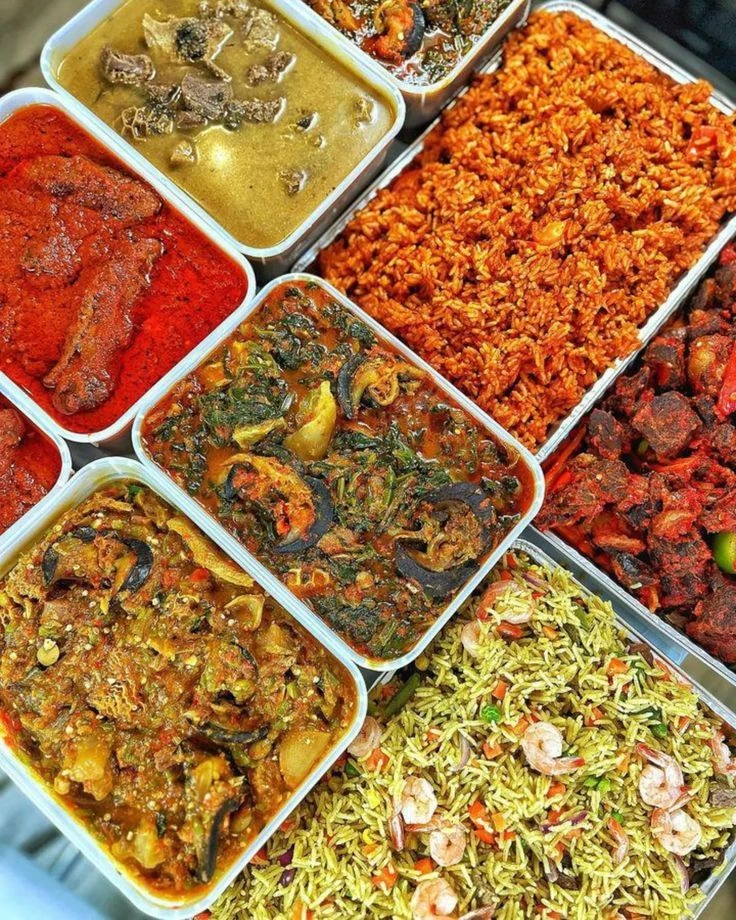 A selection of Nigerian rice, stews, soups and vegetables in serving trays