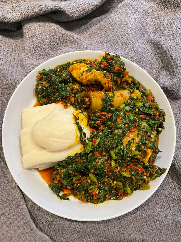Pounded yam with leafy vegetable soup and fish